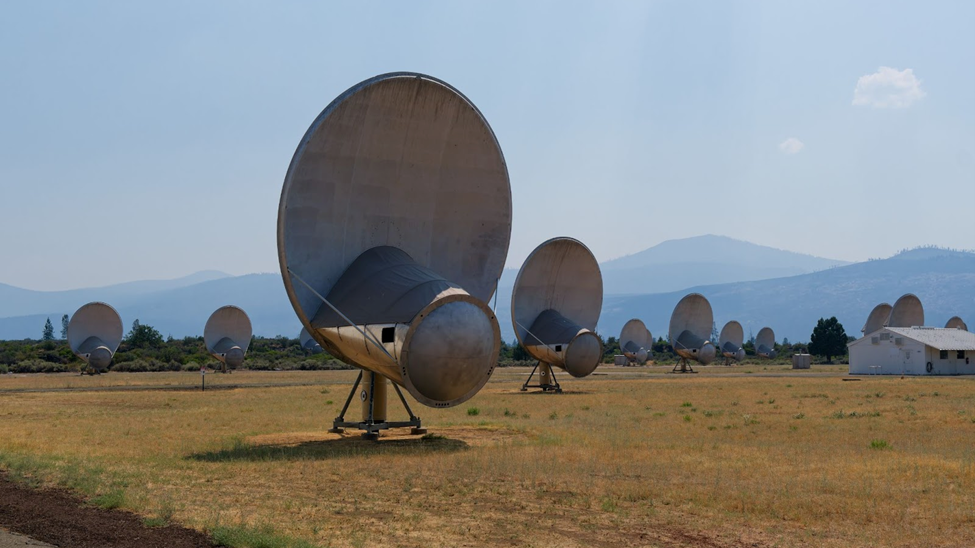 The Allen Telescope Array, a field of large radio dishes set against a mountain backdrop.